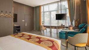 a hotel room with a bed and a living room at Shell Hotel Nanyang High-Speed Railway Station Jiangying Airport Huayaocheng in Nanyang
