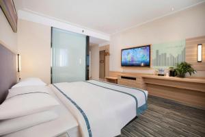 AnyangにあるCity Comfort Inn Anyang Railway Stationの大きなベッドと薄型テレビのある寝室