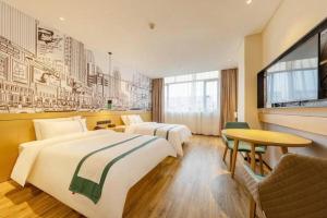 ein Hotelzimmer mit zwei Betten und einem Tisch in der Unterkunft City Comfort Inn Tonglu Fuchun River Qiaolin Road in Tonglu + 196 Fotos