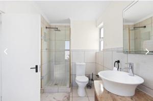 ein Badezimmer mit Waschbecken, Toilette und Dusche in der Unterkunft The Continental Sea Spray in Cape Town + 9 Fotos