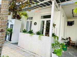a white house with plants on the facade at Tropical Homestay - Danang in Danang