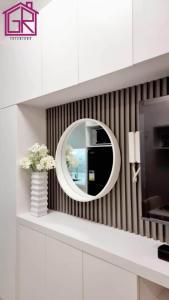 uno specchio rotondo su una parete in una stanza di Stylish Modern Condo at Shore Residences MOA a Manila
