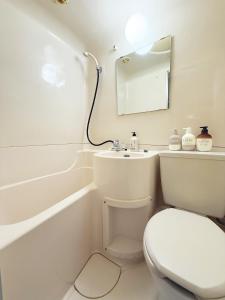 a white bathroom with a toilet and a sink at The Vera in Tokyo