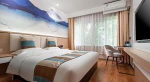 une chambre d'hôtel avec un grand lit et une télévision dans l'établissement VX Hotel Beijing Daxing Wufutang Metro Station Zhongke Dianshanggu, à Pékin