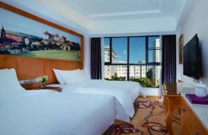 a hotel room with two beds and a large window at Vienna Hotel Kunming Beijing Road Chuanxin Gulou Metro Station in Kunming +54 photos