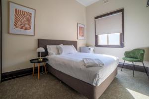 亚勒旺加Terminus Hotel Yarrawonga的一间卧室配有一张大床和一张绿色椅子