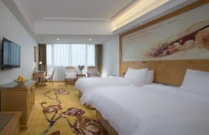 a large hotel room with two beds and a desk at Vienna Hotel Guangdong Zhaoqing Sihui Center Jade Expo Market in Zhaoqing +76 photos