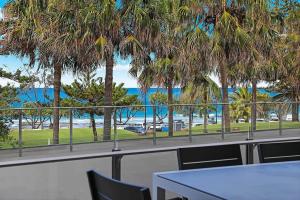 穆卢拉巴Spinnaker Apt 6- Mooloolaba Beach的棕榈树餐厅享有海滩美景