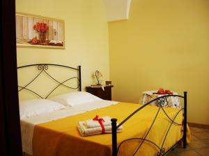 マリーナ・ディ・マンカヴェルサにあるSpruzzi di mareのベッドルーム1室(黄色いシーツと赤いリボンのベッド1台付)