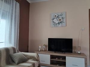 a living room with a television and a couch at Chris Apartment in Mélissa