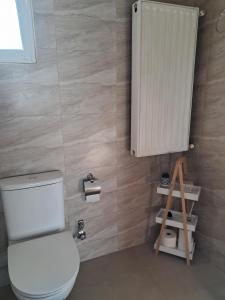 a bathroom with a toilet and a small cabinet at Chris Apartment in Mélissa