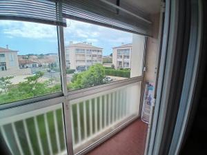 Cette chambre dispose d'une fenêtre offrant une vue sur un bâtiment. dans l'établissement Agréable T2 a 3mn de la mer parking wifi, à Six-Fours-les-Plages