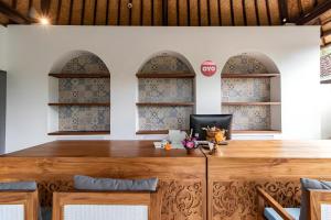 a wooden table in a room with three windows at Belvilla Y Resort Near Central Ubud in Ubud