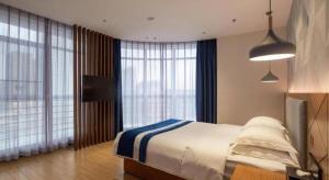 Postel nebo postele na pokoji v ubytování Borrman Hotel Shaoguan Nanxiong Rt-Mart