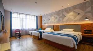 Postel nebo postele na pokoji v ubytování Borrman Hotel Shaoguan Nanxiong Rt-Mart