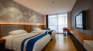 Postel nebo postele na pokoji v ubytování Borrman Hotel Shaoguan Nanxiong Rt-Mart