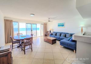 a living room with a blue couch and a table at Above The Dunes in Woorim +30 photos