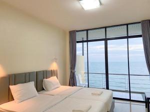 una camera da letto con un letto con vista sull'oceano di Phala Shore Resort a Ban Phala
