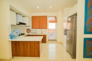 a kitchen with a sink and a refrigerator at UNA Services - Elysium Apartments in Islamabad