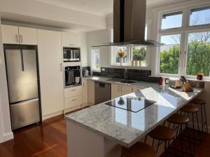 a kitchen with a large marble counter top with stools at Sackville Retreat in Martinborough
