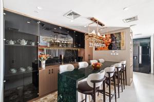 迪拜Skyline Vista 3-Bedroom Haven with Lagoon Retreat的厨房设有带绿色柜台和凳子的酒吧