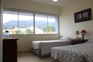 una camera d'albergo con due letti e una grande finestra di Hotel Doral a Città di Panama