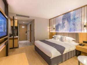 Un dormitorio con una cama grande y un televisor de pantalla plana. en GreenTree Eastern Hotel Tianjin Dongli Development Zone Xinli Metro Station, en Tianjin