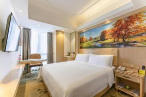 a hotel room with a bed and a painting on the wall at Vienna Hotel Chongqing Yangjiaping Pedestrian Street Light Railway Station in Chongqing