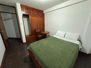 une chambre avec un lit avec une couverture verte dans l'établissement Departamento con Vista al Mar 1er Fila, à Pimentel