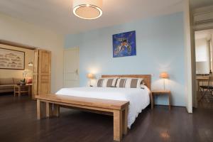 サン・テミリオンにあるDemeure des Girondinsのベッドルーム(大型ベッド1台、木製ベンチ付)