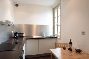 uma cozinha com uma mesa e dois copos de vinho em Demeure des Girondins em Saint-Émilion