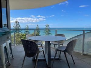 un tavolo e sedie su un balcone con vista sull'oceano di Breeze 801 a Mooloolaba