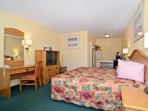 a hotel room with a bed and a desk at Americas Best Value Inn Alexandria in Alexandria