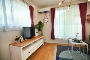 uma sala de estar com uma televisão de ecrã plano numa cómoda em SCD155 Spacious Villa in Ikebukuro Suburbs Direct Access to Tokyo's Core Commercial Districts em Tóquio