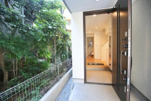 uma porta aberta que leva a um corredor com árvores em SCD155 Spacious Villa in Ikebukuro Suburbs Direct Access to Tokyo's Core Commercial Districts em Tóquio