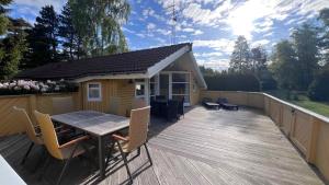 a deck with a table and chairs and a shed at Super Cozy Holiday Home In Marielyst in Marielyst