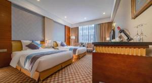 a hotel room with two beds and a desk at Nanning Yongjiang Hotel in Nanning
