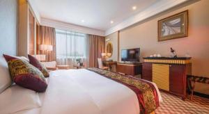a hotel room with a large bed and a television at Nanning Yongjiang Hotel in Nanning