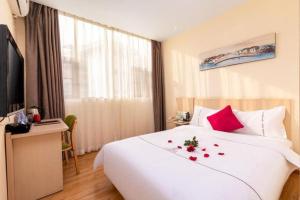 a hotel room with a bed with roses on it at Shang Pin Hotel Shenzhen Futian Exhibition Branch in Shenzhen +88 photos