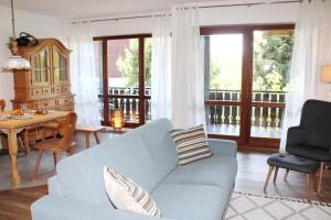 a living room with a blue couch and a table at See & Bergliebe in Chieming +19 photos