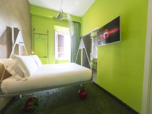 a room with a bed with a green wall at iRooms Central Station in Rome +66 photos
