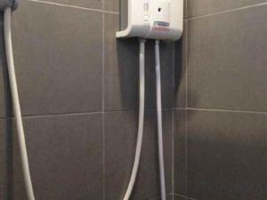 a phone is hanging on a wall in a bathroom at Nithra Ratree Hotel in Si Maha Phot +70 photos