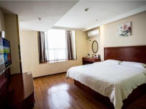 a bedroom with a large bed and a large window at GreenTree Inn Luoyang Zhongzheng Street Express Hotel in Luoyang