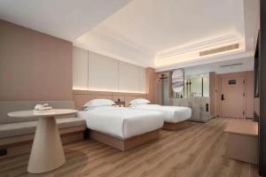 a hotel room with two beds and a table at Jinjiang Inn Haikou Jinjiuling Park Branch in Haikou +254 photos