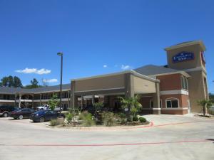 ein großes Gebäude mit einem Parkplatz davor in der Unterkunft Executive Inn and Suites Tyler in Tyler