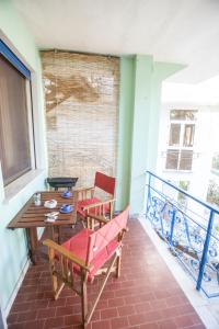 a balcony with a wooden table and two chairs at Charming 2-room apartment in a peaceful residential area in Rosolina Mare
