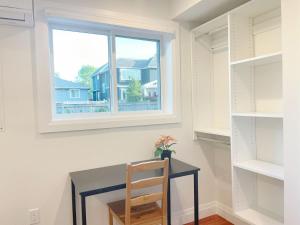 a desk with a chair in a room with a window at Brand new, peaceful first floor room for staying in Vancouver +1 photo