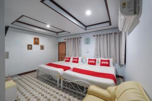 ein Schlafzimmer mit einem großen Bett mit roten und weißen Kissen in der Unterkunft OYO 75308 Pea Najan Home Resort in Sai Yok