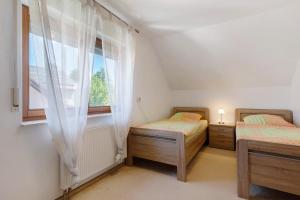 a bedroom with two twin beds and a window at Ferienhaus am Mühlenbach, 110qm in Schwanau