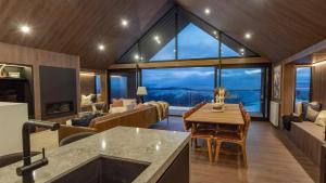 a living room with a table and a large window at Peak Chalet in Mount Hotham